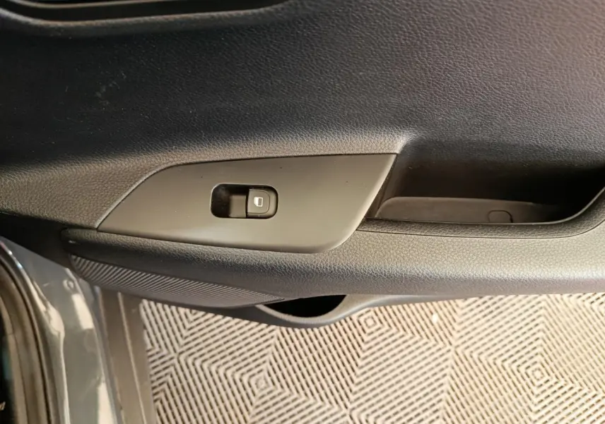 Détail de la porte côté conducteur du Kia Stonic gris foncé 2023 avec bouton de verrouillage centralisé.