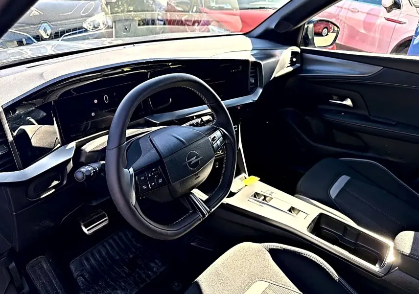 Vue intérieure côté conducteur de l'Opel Mokka Electric gris 2025, volant multifonction et tableau de bord numérique.