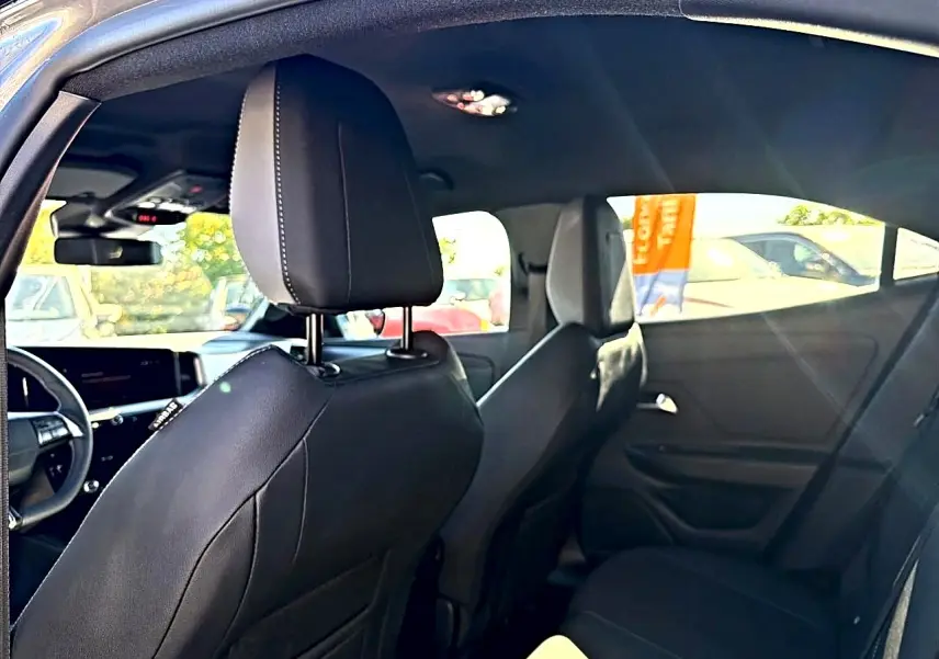 Vue intérieure arrière droite de l’Opel Mokka Electric 156 GS 2025 avec sièges noirs et tableau de bord partiellement visible.