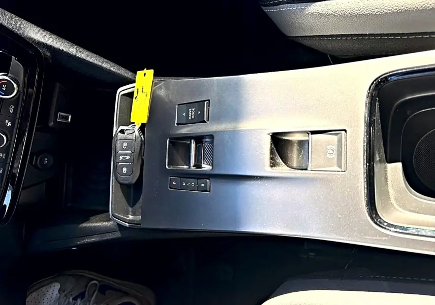 Vue plongeante sur la console centrale grise de l’Opel Mokka Electric 156 gs avec clé et commandes de boîte automatique.