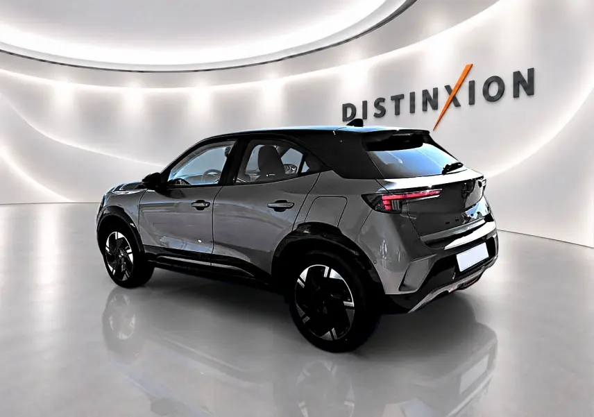 Opel Mokka Electric gris en 3/4 arrière droit, avec toit noir et jantes alu noires brillantes.