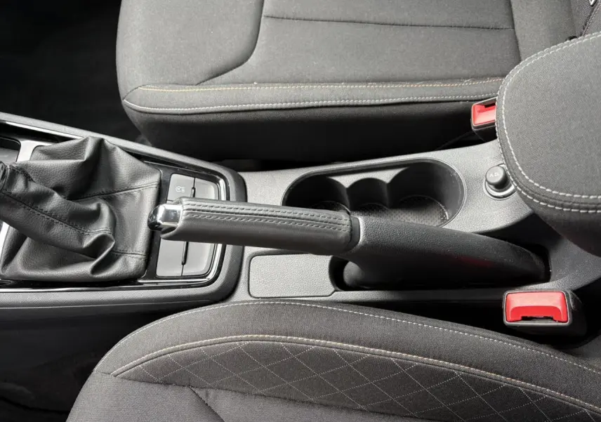 Vue rapprochée de la console centrale avec frein à main et accoudoir en tissu noir du Skoda Kamiq 2024.