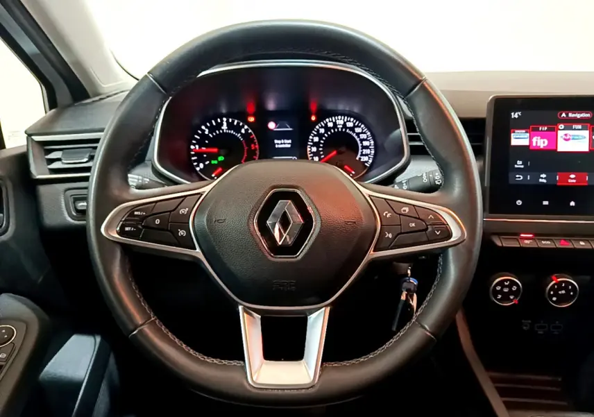 Vue rapprochée du volant en cuir noir de la Renault Clio Business Blue dCi 85 2020 avec tableau de bord et écran tactile.