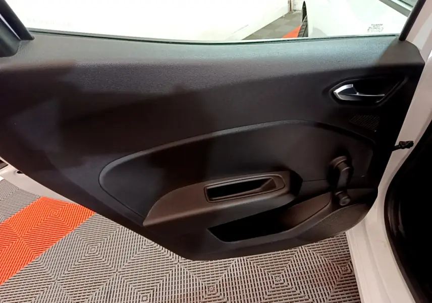 Gros plan sur la porte côté droit ouverte d'une Renault Clio Business Blue dCi 85 blanche, intérieur noir simple.