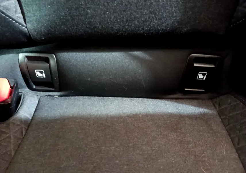 Détail des commandes de rabattement des sièges arrière noirs dans une Renault Clio Business Blue dCi 85 blanche de 2020.