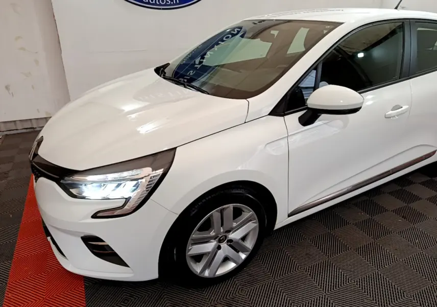 Renault Clio Business Blue dCi 85 blanche vue en 3/4 avant droit, avec phares LED allumés et jantes alliage.