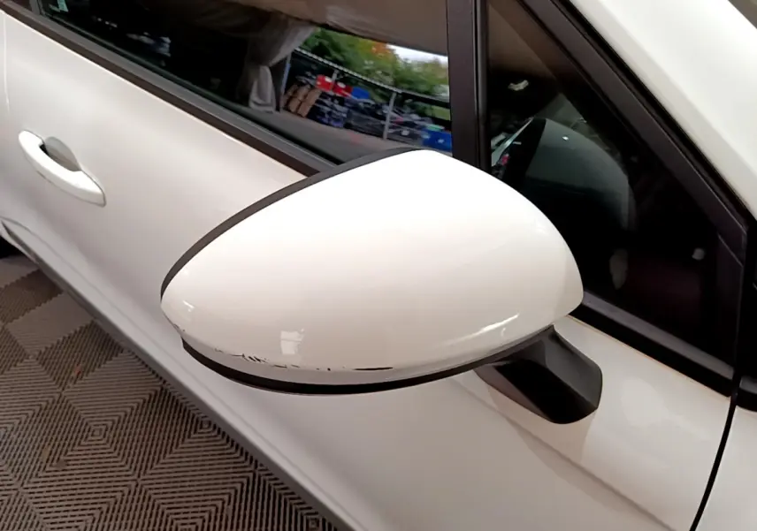 Rétroviseur côté gauche blanc de Renault Clio Business Blue dCi 85 2020 avec rayures visibles sur le bord inférieur.