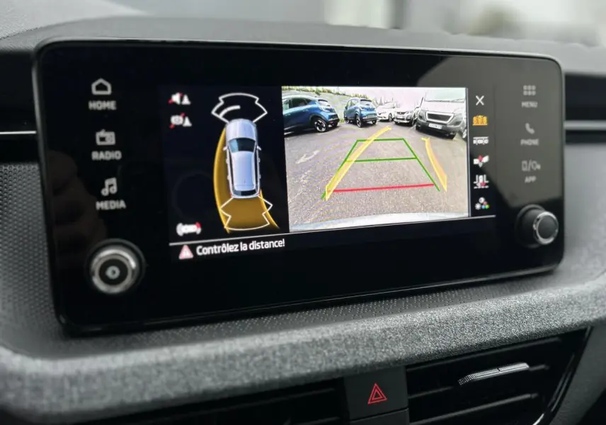 Écran tactile intérieur montrant la caméra de recul et l'aide au stationnement du Skoda Kamiq gris graphite.