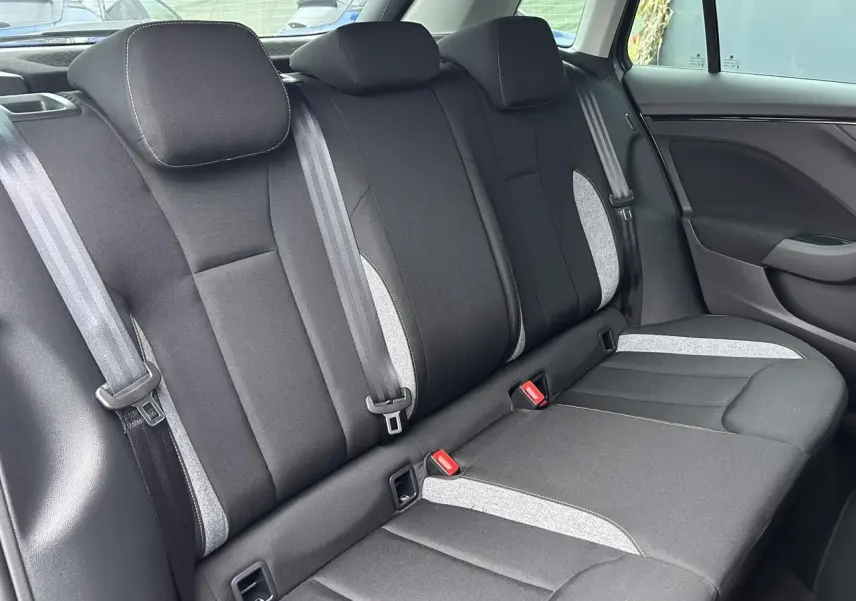 Vue latérale de la banquette arrière noire et grise du Skoda Kamiq 2025 avec ceintures et appuie-têtes intégrés.