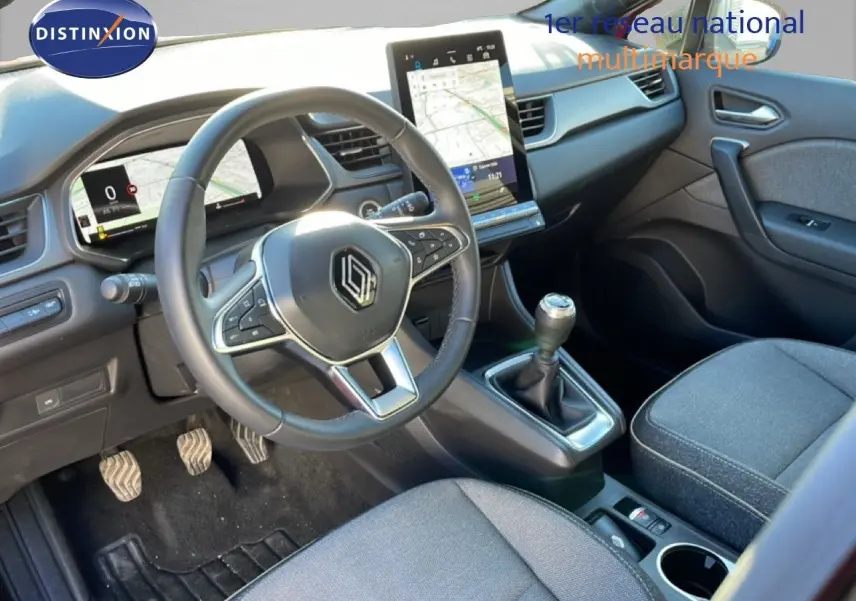 Vue intérieure avant droite du Renault Captur 2025, volant cuir, tableau de bord digital et console centrale avec boîte manuelle.