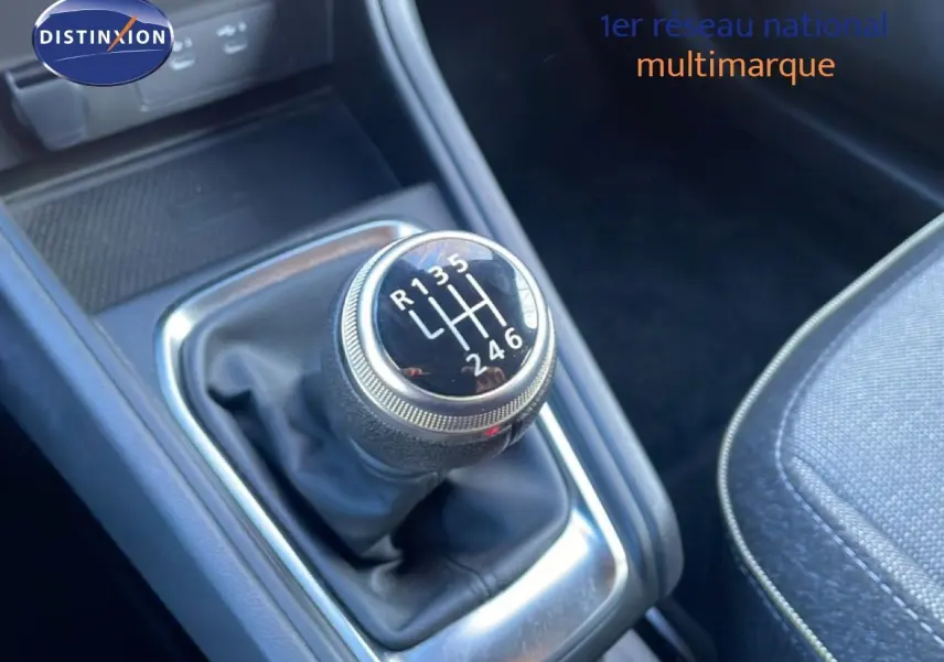 Gros plan sur le levier de vitesses manuel du Renault Captur 2025, avec sellerie tissu gris et console noire.