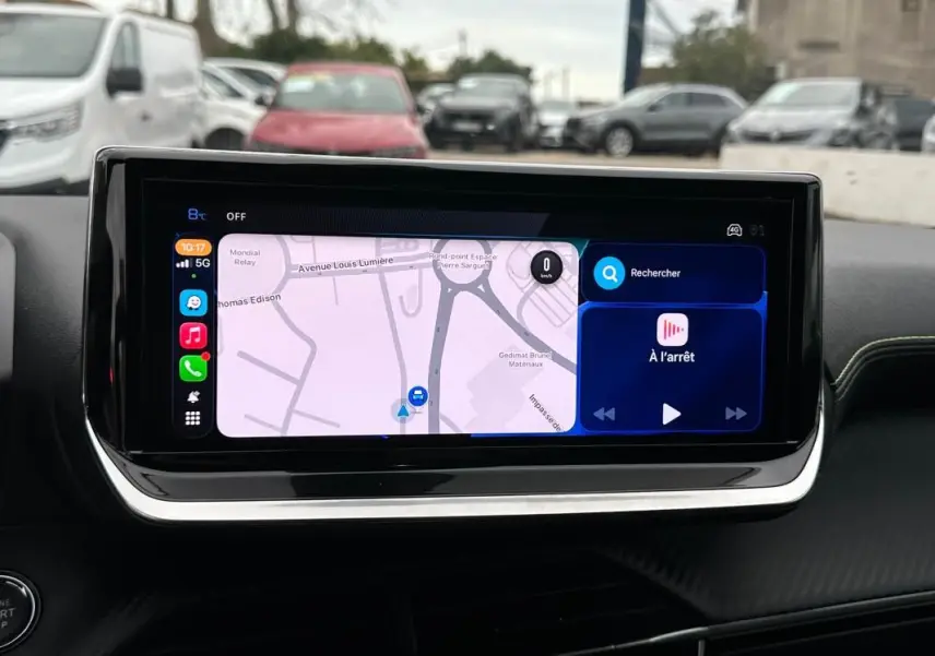 Écran tactile du tableau de bord de la Peugeot 208 Hybrid gris, affichant la navigation et les commandes multimédia.