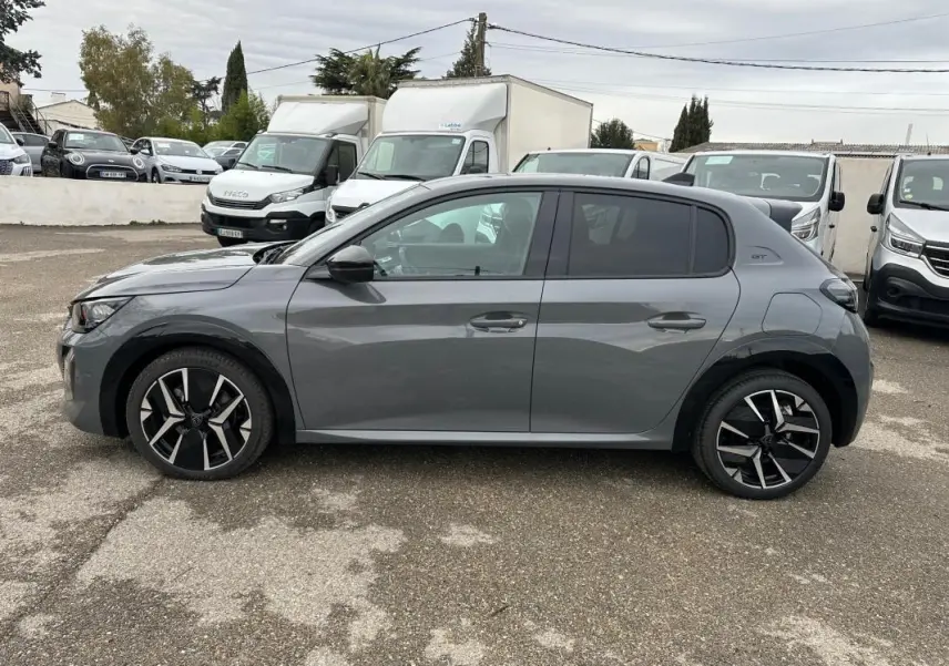 Peugeot 208 Hybrid 110 e-DCS6 GT gris vue de profil côté gauche, avec jantes alliage 17 pouces et toit noir.
