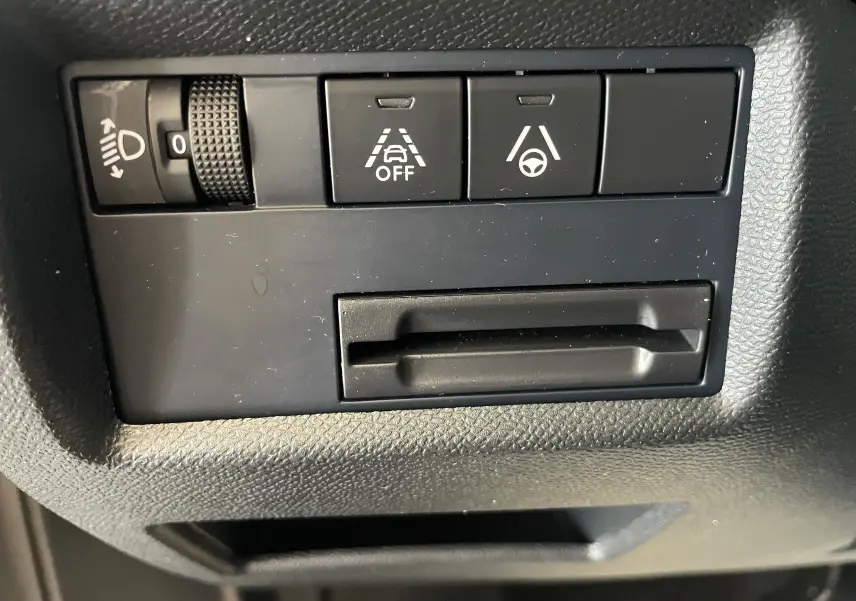 Gros plan sur les commandes noires du tableau de bord du Citroën C5 Aircross hybride gris platinium, boutons d'assistance à la conduite.