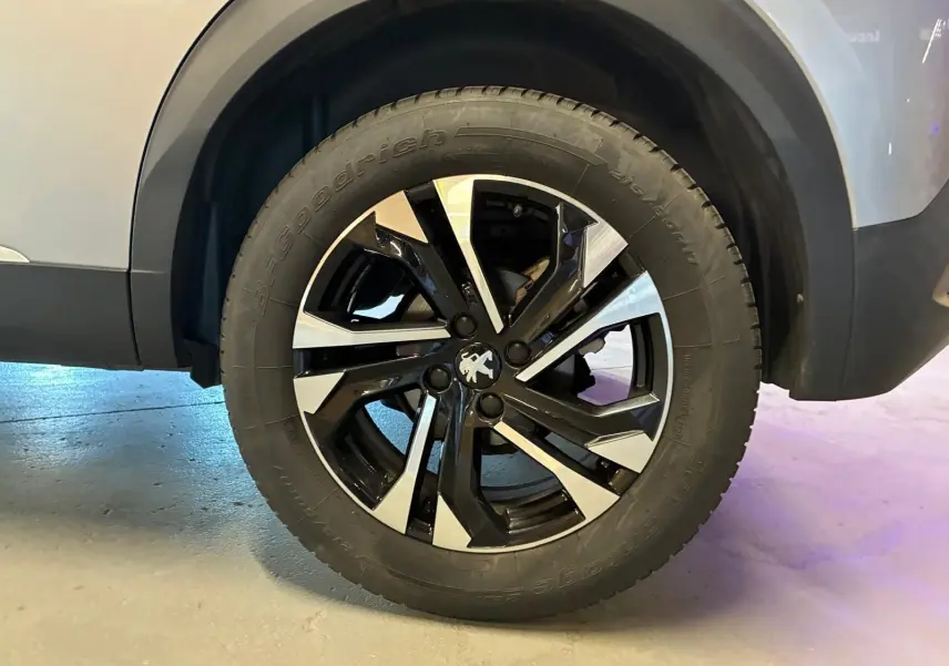 Gros plan sur la roue avant droite du Peugeot 2008 gris 2022, mettant en valeur la jante alliage noire et argentée.