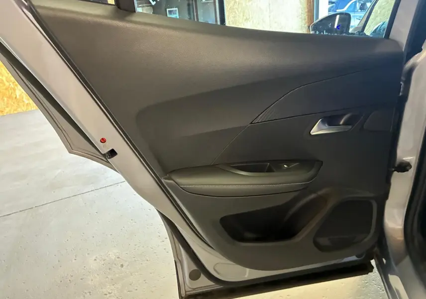 Vue intérieure de la porte arrière droite gris clair du Peugeot 2008 1.5 BlueHDi 2022 avec garniture noire et poignée argentée.