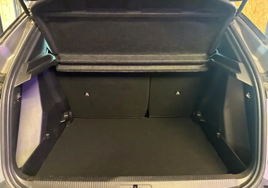 Coffre ouvert vu de l'arrière d'un Peugeot 2008 gris 2022, espace de chargement propre et vide.