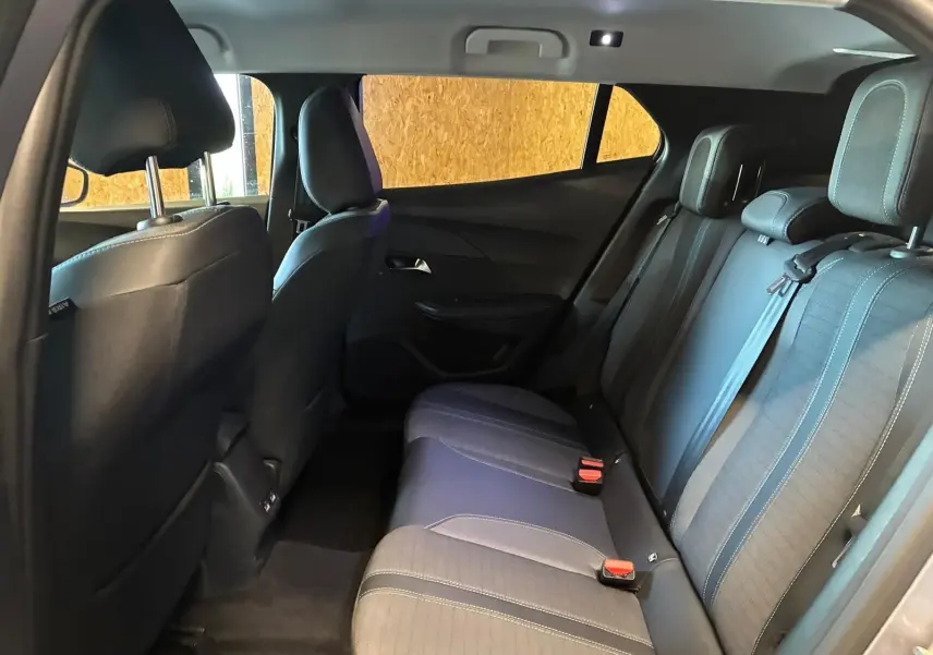 Intérieur arrière du Peugeot 2008 gris 2022, vue côté droit montrant les sièges en tissu noir avec appuie-têtes et ceinture de sécurité.