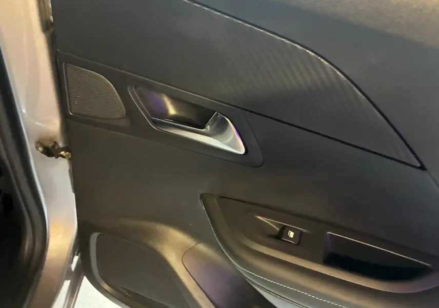 Vue rapprochée de la porte avant gauche gris clair du Peugeot 2008 avec poignée argentée et commande de fenêtre.