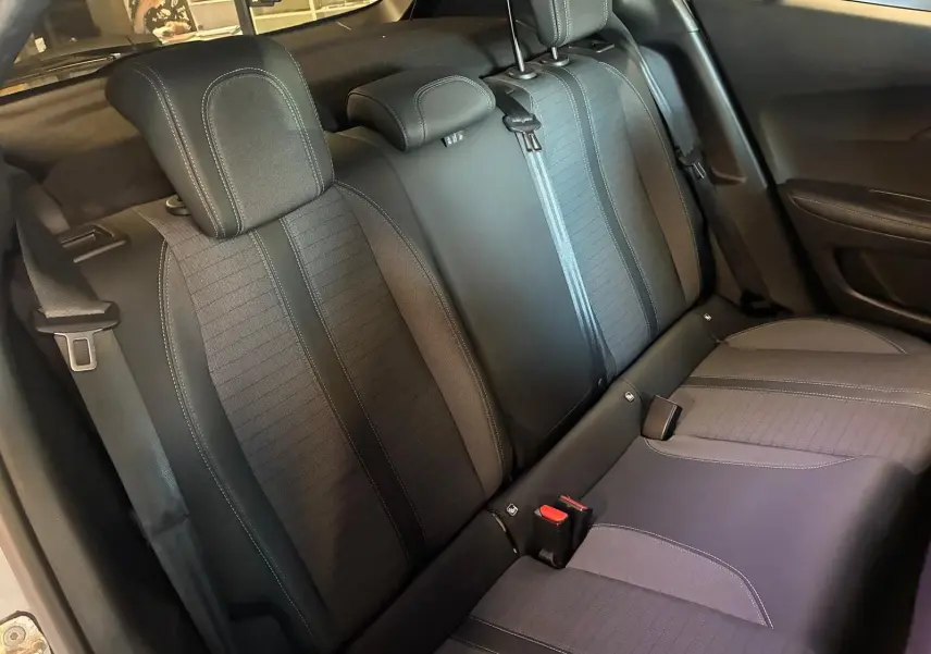 Vue intérieure sur les sièges arrière en tissu noir du Peugeot 2008 1.5 BlueHDi 130 gris, avec appuie-têtes et ceintures visibles.