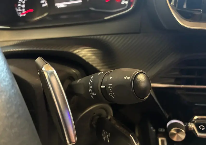 Gros plan sur la manette d’essuie-glace côté gauche du tableau de bord du Peugeot 2008 gris, version 2022.