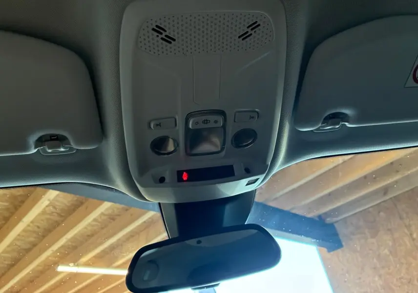 Vue intérieure du plafonnier et du rétroviseur central d’un Peugeot 2008 gris, avec commandes d’éclairage et détecteur.
