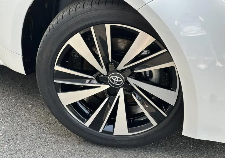 Gros plan sur la jante alliage 17 pouces bicolore noir et argent du Toyota Corolla Touring Sport blanc neige.