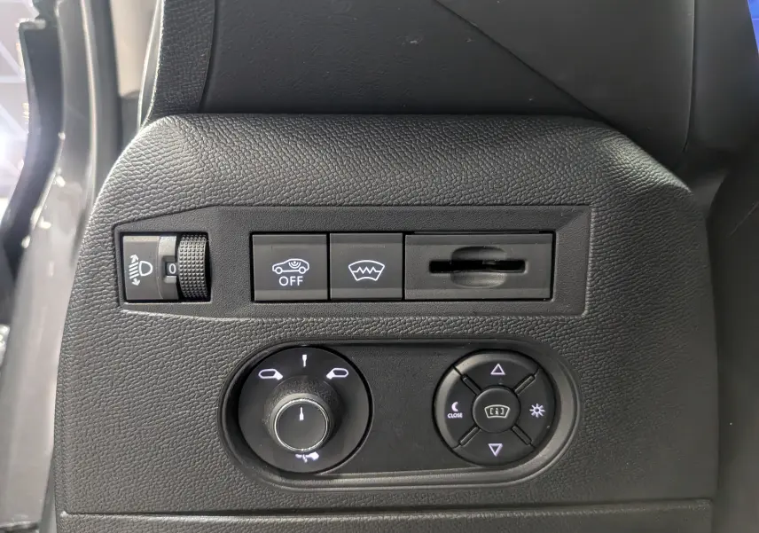 Panneau de commande intérieur noir avec réglages des phares et des rétroviseurs sur DS3 Gris Platinium 2024.