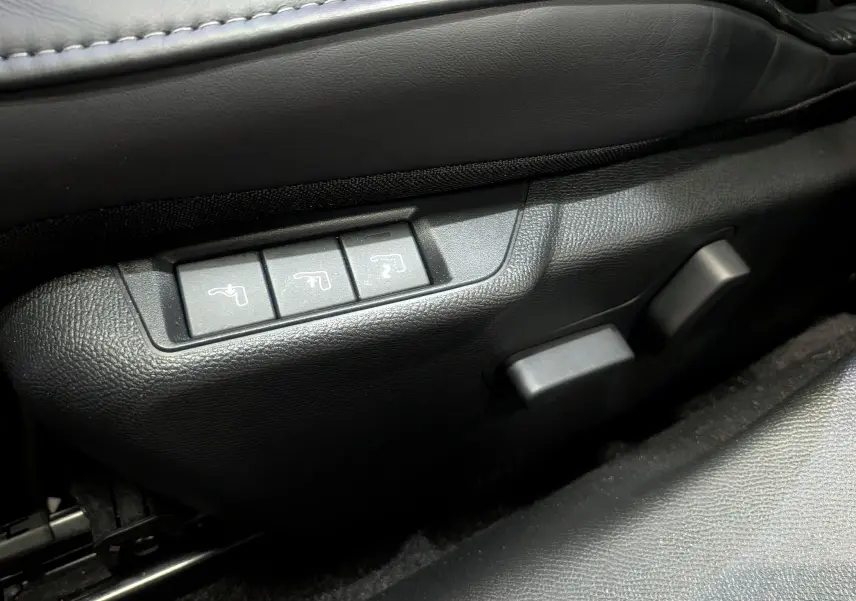 Détail des commandes de réglage électrique des sièges en cuir noir dans une DS3 PureTech 2024.