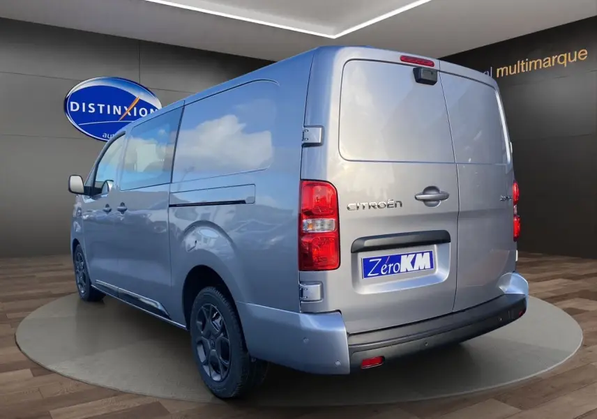 Vue 3/4 arrière droite d'un Citroën Jumpy cabine approfondie gris acier avec portes arrière battantes et jantes noires.