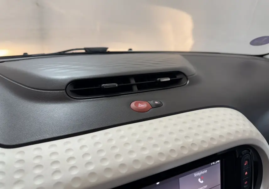 Détail du tableau de bord noir et blanc avec bouton de warning rouge sur Renault Twingo Equilibre 2022.