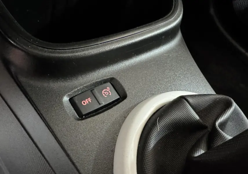 Gros plan sur le bouton de désactivation du régulateur de vitesse près du levier de vitesses d'une Renault Twingo blanche 2022.