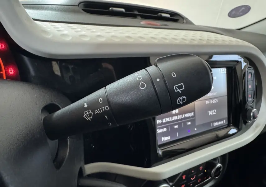 Gros plan sur la commande d'essuie-glace noire dans l'habitacle blanc de la Renault Twingo Equilibre 2022.