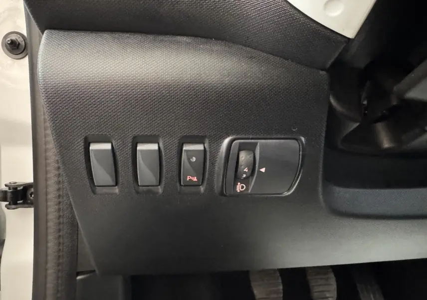 Vue rapprochée des commandes noires côté gauche du tableau de bord d'une Renault Twingo blanche 2022.