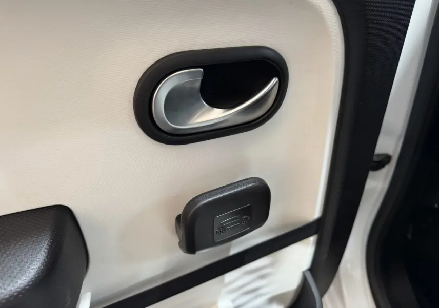 Gros plan sur la poignée intérieure de porte blanche côté conducteur d'une Renault Twingo Equilibre 2022.