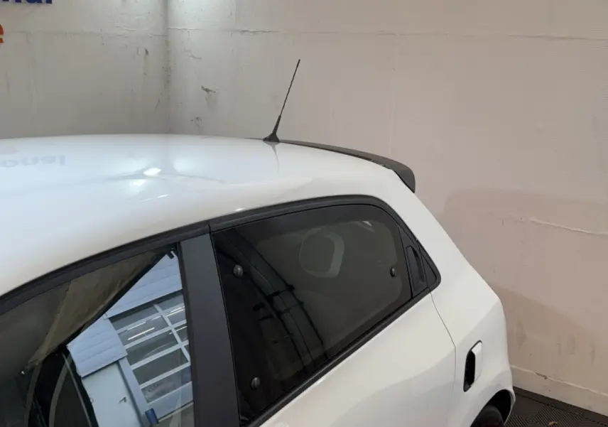 Vue côté gauche arrière d'une Renault Twingo blanche 2022 avec antenne de toit et vitre teintée arrière