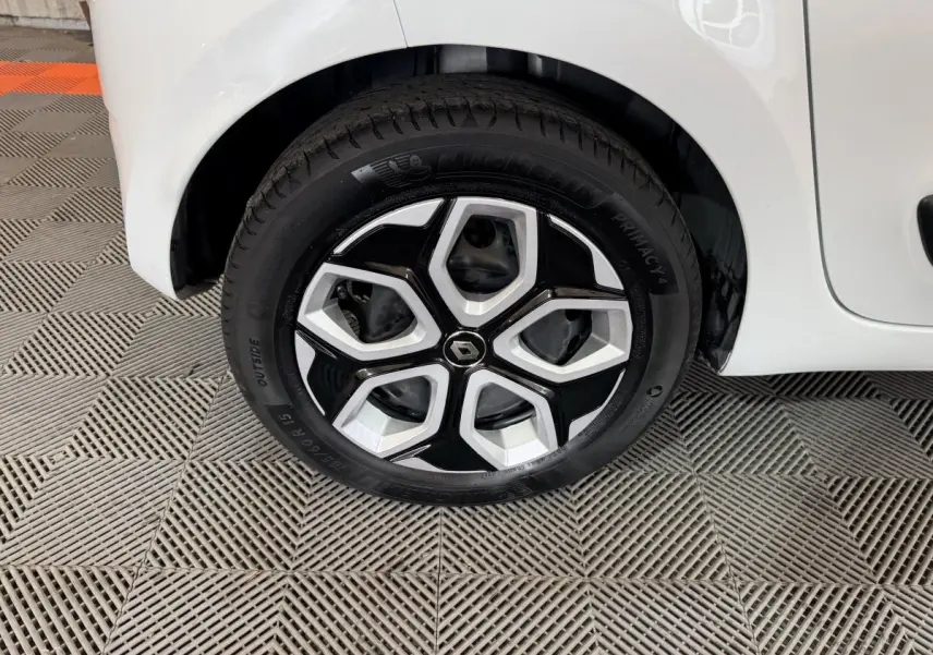 Gros plan sur la roue avant gauche blanche d’une Renault Twingo 2022 avec jante noire et argentée au design géométrique.