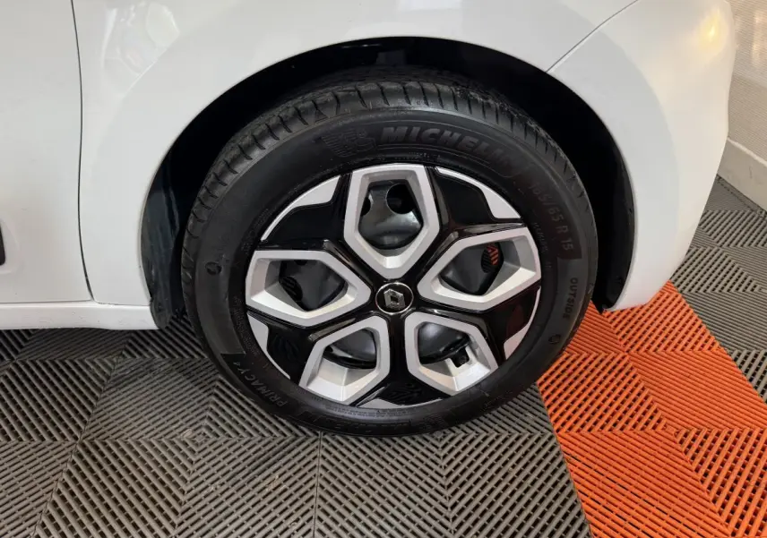 Gros plan sur la roue avant droite blanche d'une Renault Twingo 2022 avec jante en alliage noir et argent.