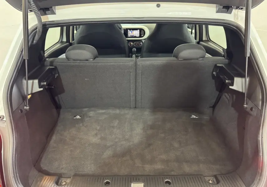 Coffre ouvert vu de l'arrière d'une Renault Twingo blanche 2022, montrant la banquette arrière et l'intérieur noir.