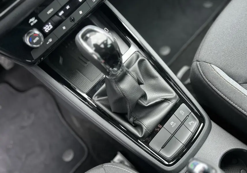 Gros plan sur la console centrale du Skoda Kamiq gris graphite, avec levier de vitesses automatique et commandes de confort.