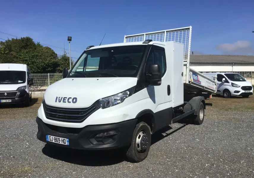 IVECO Daily Chassis Cabine blanc en 3/4 avant droit avec benne acier et coffre latéral visible.