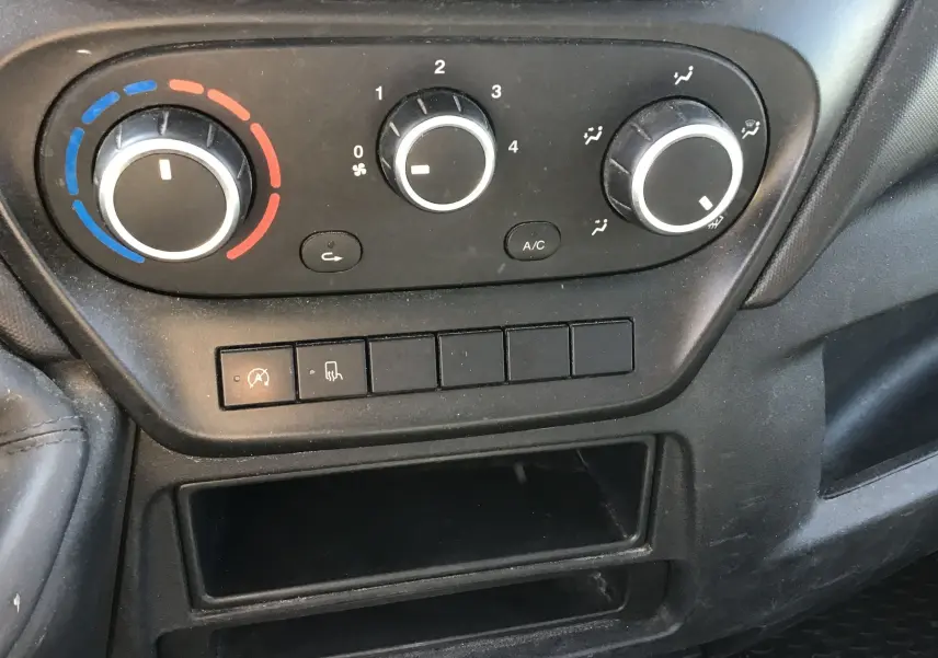 Tableau de bord noir avec commandes de climatisation et ventilation du véhicule Iveco Daily Chassis Cabine blanc, vue intérieure rapprochée.