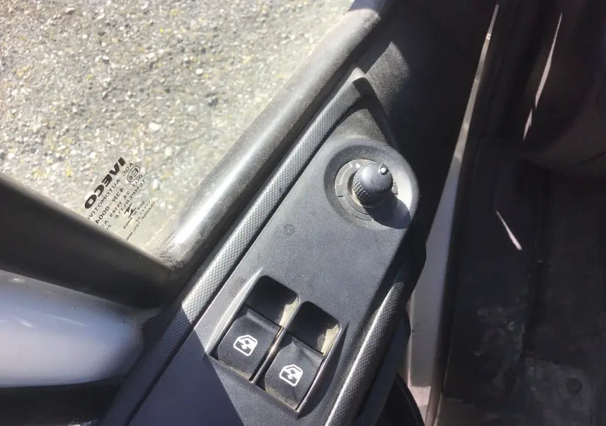 Détail du panneau de commande des vitres électriques et réglage des rétroviseurs côté conducteur d’un Iveco Daily blanc.