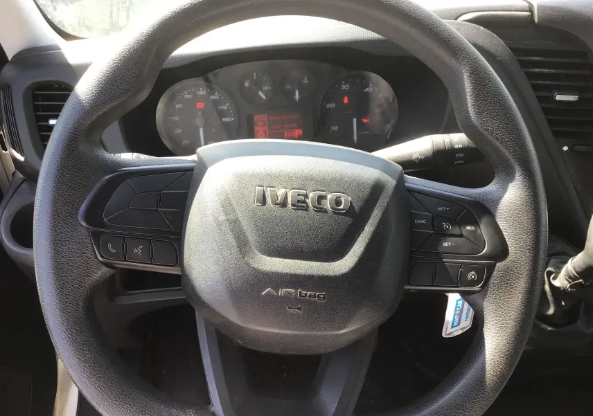 Vue rapprochée du volant noir marqué IVECO du Daily Chassis Cabine 35C14 blanc, avec tableau de bord en arrière-plan.