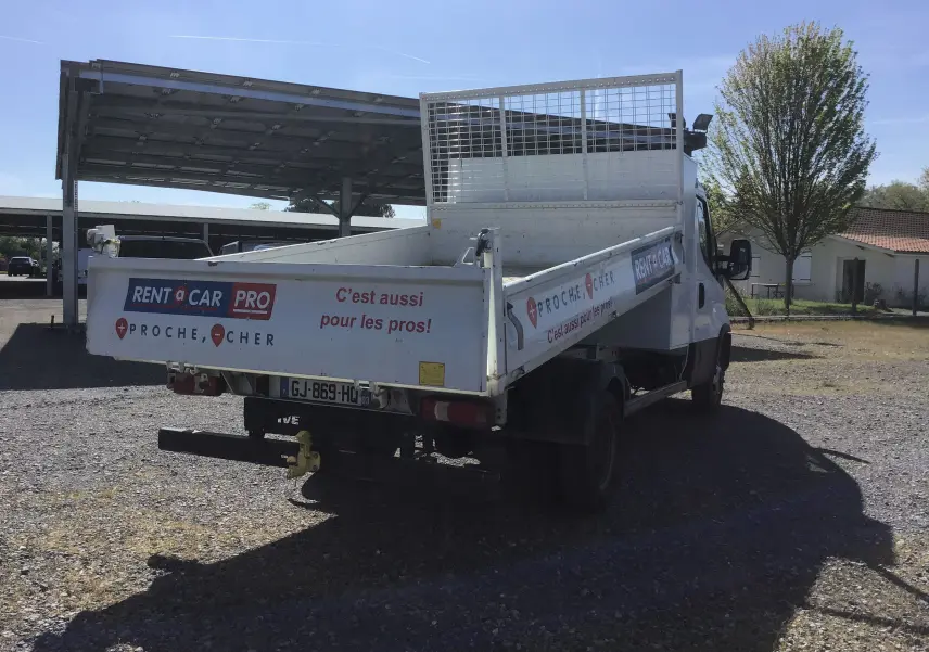 IVECO Daily Chassis cabine blanc vu en 3/4 arrière droit avec benne acier et marquages publicitaires Rent a Car Pro.