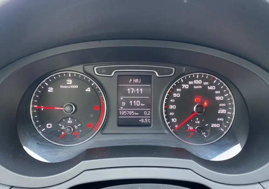 Vue rapprochée du tableau de bord noir de l'Audi Q3 2.0 TDI 2014 avec compteur et écran digital central.