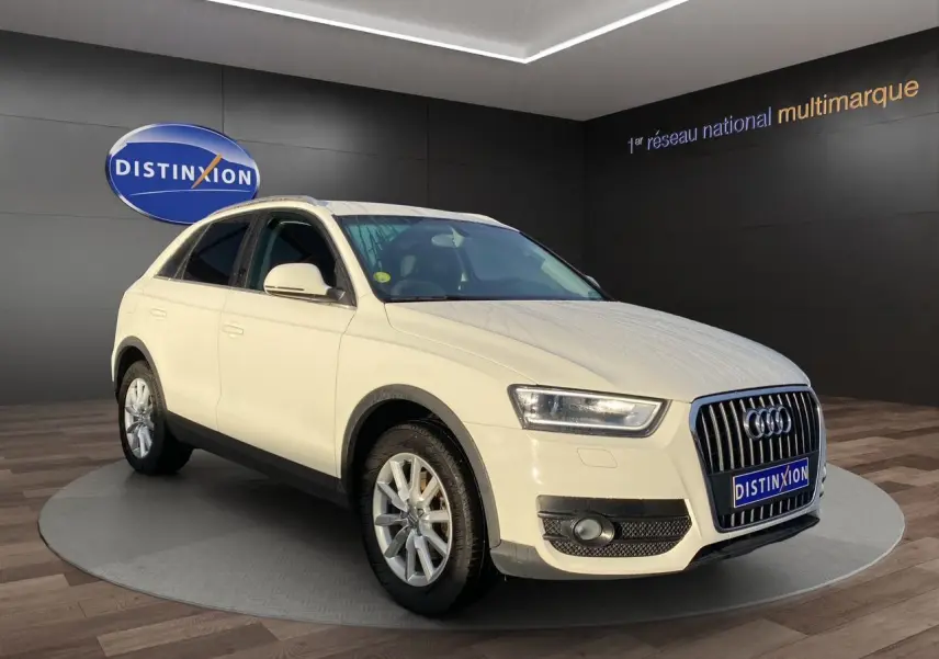 Audi Q3 blanc en 3/4 avant droit avec vitres arrière surteintées, présenté en showroom Distinxion.