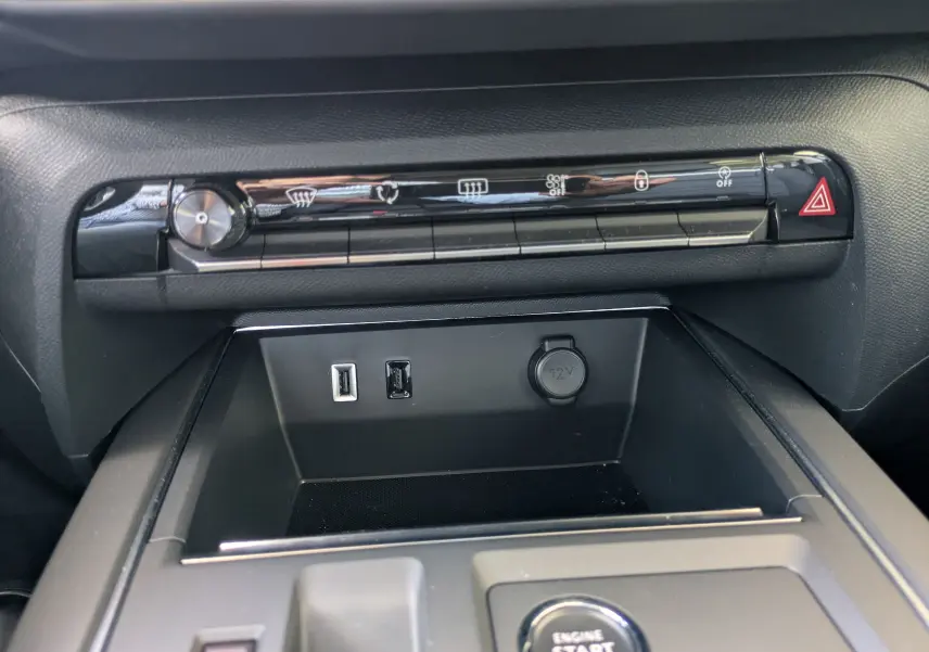 Vue rapprochée de la console centrale noire du Citroën C5 Aircross hybride 2025, avec boutons de commande et ports USB visibles.