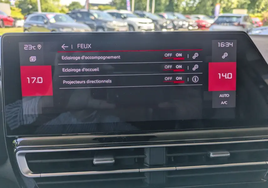 Écran tactile central du Citroën C5 Aircross Hybride 2025 affichant les réglages des feux, avec tableau de bord noir brillant.
