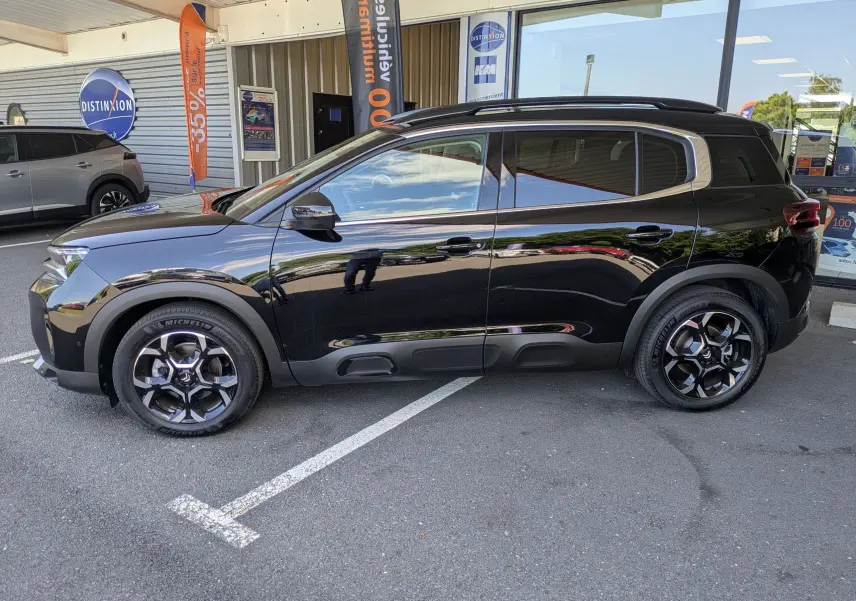 Profil côté gauche d'un Citroën C5 Aircross Hybride 2025 noir perla avec jantes alliage 18 pouces biton, vitres surteintées.